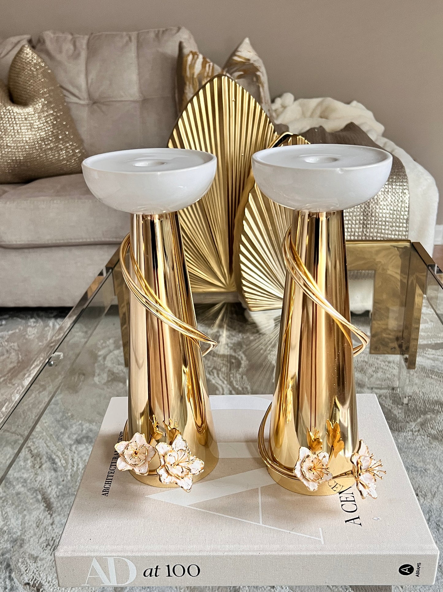 Gold candleholders whit flower detail.