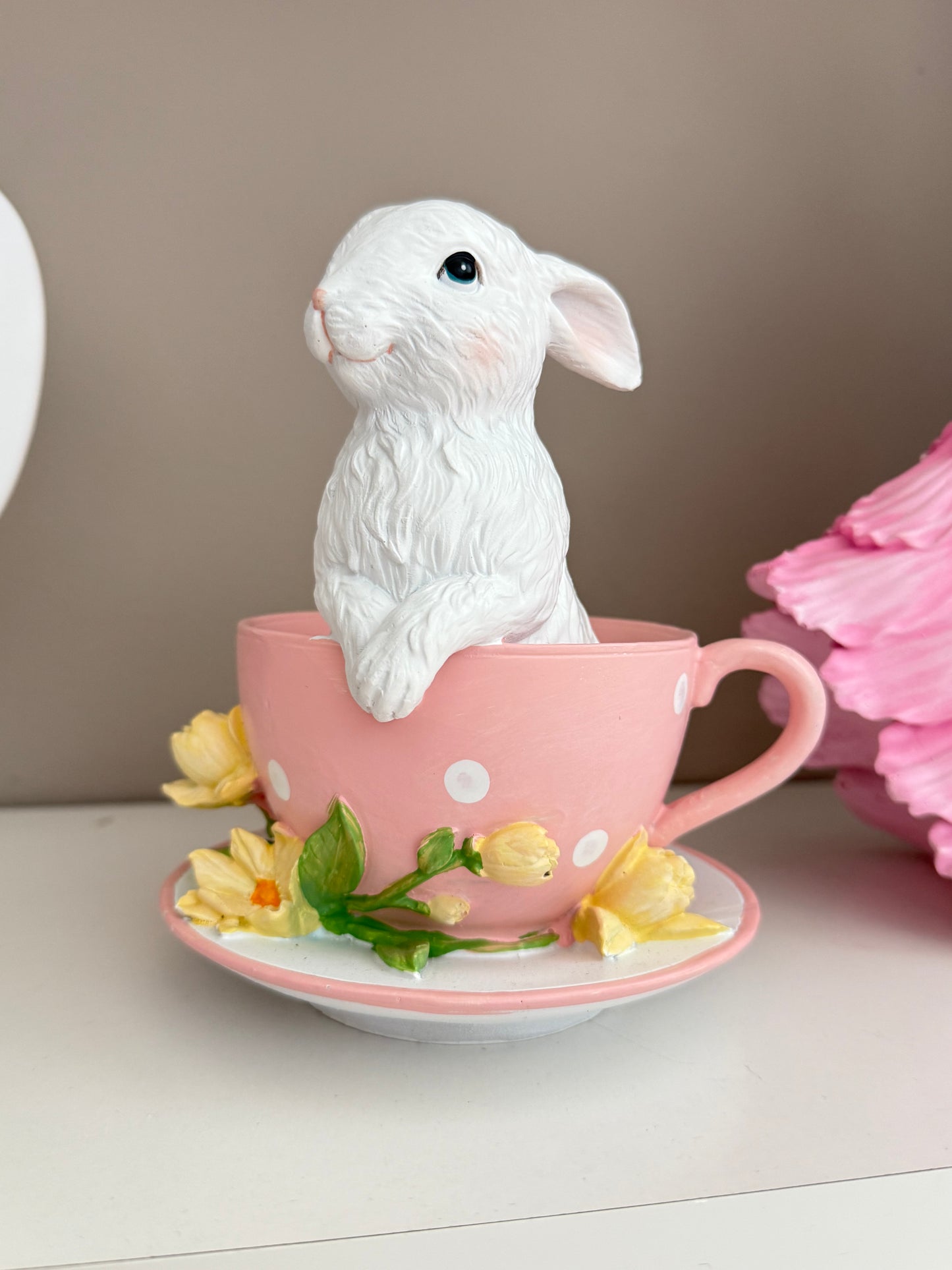 white rabbit sitting inside a pink and white polka-dot
