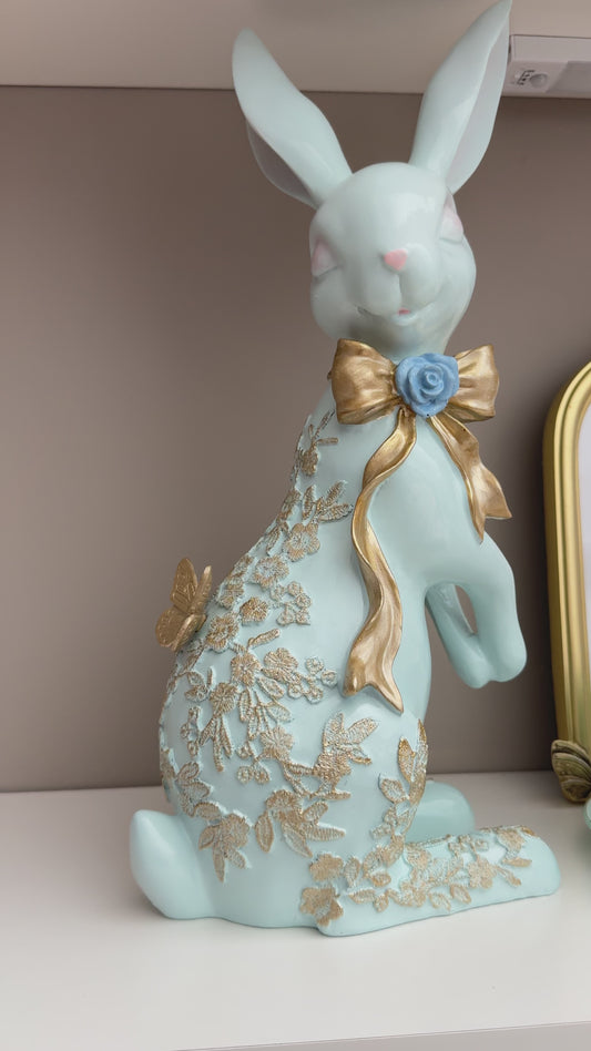 blue Easter spring bunny figurine with a gold bow and butterfly details.